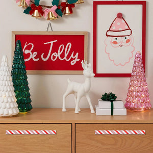 Decorative Christmas scene with framed art, ornaments, and a wreath.