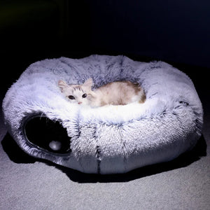Cat lying on a fluffy pet bed with a dark background
