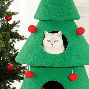 Green cat tree shaped like a Christmas tree with red ornaments and a white cat peeking out.