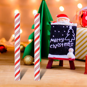 Small Santa Claus figure with a 'Merry Christmas' sign between two candy canes on a festive background.