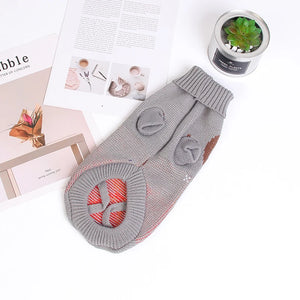 Festive knitted dog sweater in gray with decorative pattern - styled flat lay
