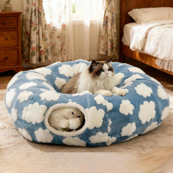 Two cats relaxing on a blue donut cat tunnel cave bed with white cloud pattern and side entrance, cozy indoor cat bed for multi‑cat homes.