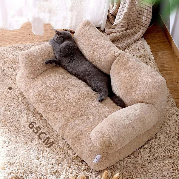 Gray cat stretched out on beige plush cat bed sofa, 65cm size, with backrest and side pillows—comfortable winter nest for cats and small dogs.