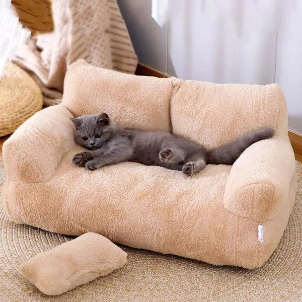 Gray cat lounging on beige plush cat bed sofa with backrest and side pillows, winter warm pet nest for cats and small dogs.