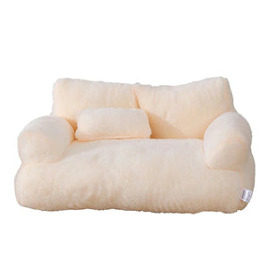 Cream plush cat bed sofa with backrest and side pillows, soft and cozy pet nest for cats and small dogs.