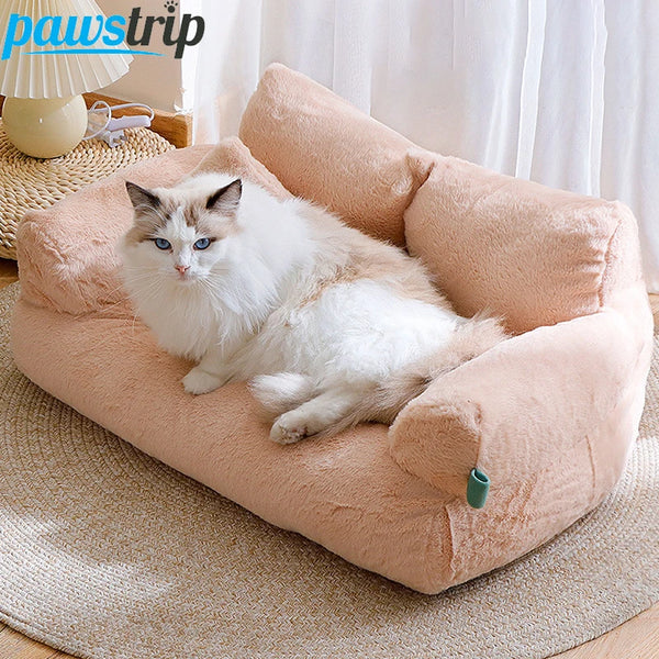 Fluffy white cat lying on peach plush cat bed sofa with backrest and side pillows, cozy winter nest for cats and small dogs.