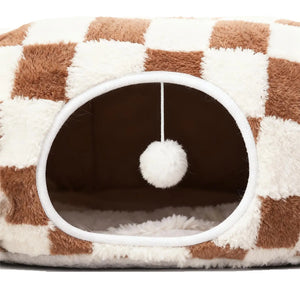 Checkerboard donut cat tunnel cave bed entrance with hanging plush toy ball and soft padded floor for indoor cats.
