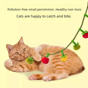 Orange cat lying on floor playing with tomato and persimmon plush ball cat teaser string toy, non‑toxic interactive boredom relief toy for indoor cats.